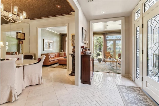 foyer entrance featuring crown molding, a notable chandelier, visible vents, and light tile patterned floors