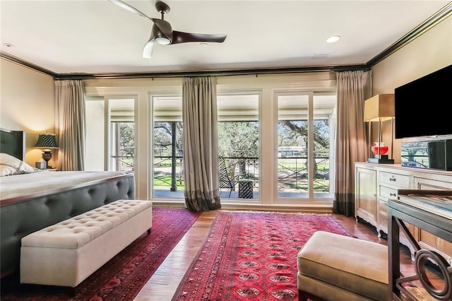 bedroom with ceiling fan, wood finished floors, and crown molding