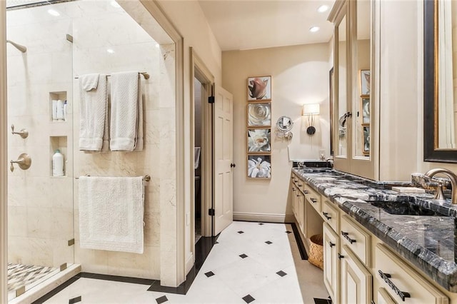 bathroom with baseboards, tiled shower, double vanity, recessed lighting, and a sink