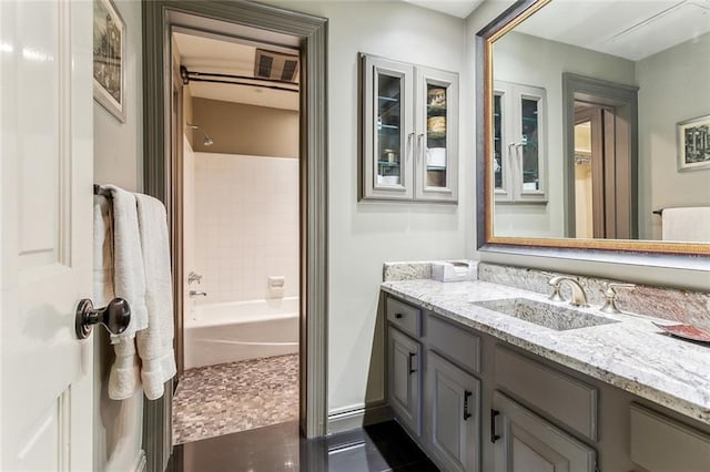 full bath featuring vanity, tile patterned flooring, baseboards, and shower / bathtub combination