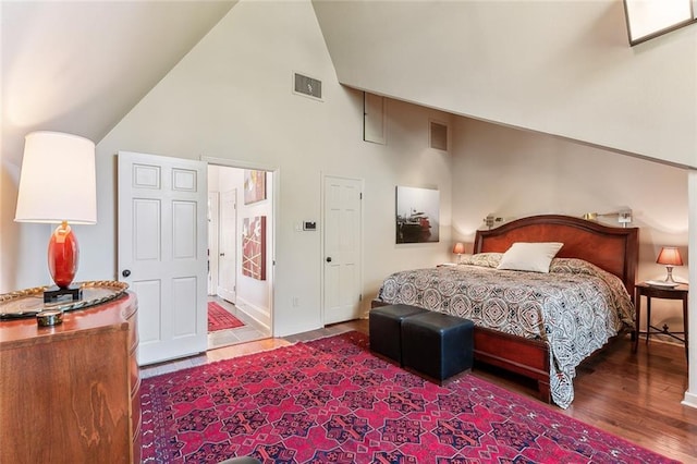 bedroom with visible vents, high vaulted ceiling, and wood finished floors