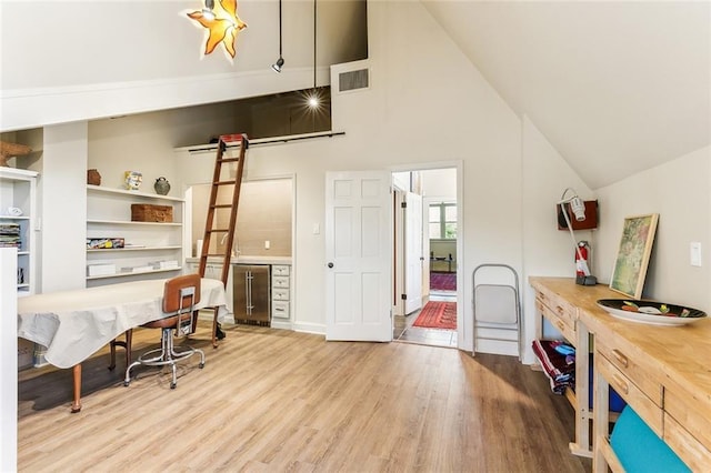 office with visible vents, high vaulted ceiling, and wood finished floors