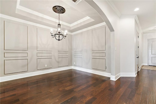 unfurnished dining area featuring an inviting chandelier, a tray ceiling, crown molding, and arched walkways