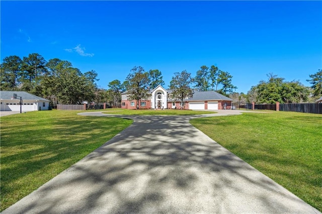 ranch-style house with driveway, a front yard, and fence