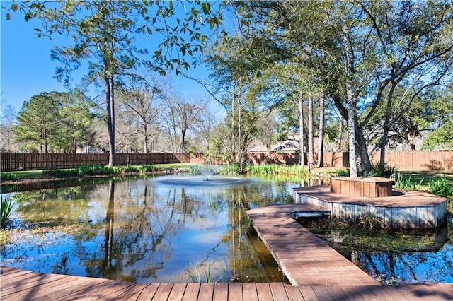 dock area with a water view and fence