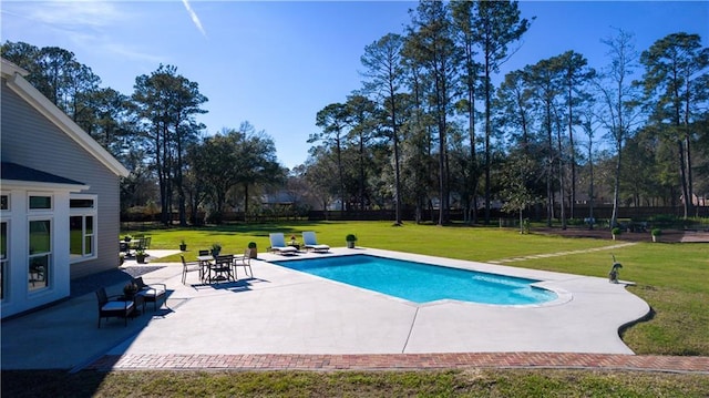 pool featuring a lawn and a patio area