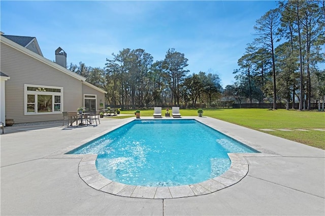 outdoor pool with a patio and a yard