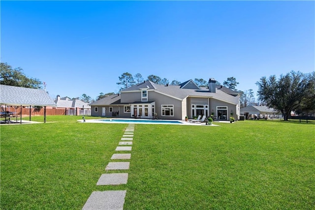 back of property featuring a fenced in pool, a lawn, a patio area, and fence