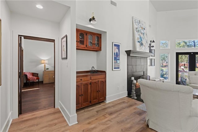 living room featuring visible vents, recessed lighting, light wood-style floors, a fireplace, and baseboards