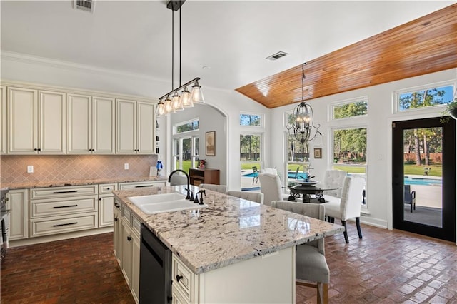 kitchen with dishwasher, cream cabinetry, and tasteful backsplash