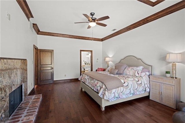 bedroom with visible vents, baseboards, a fireplace, hardwood / wood-style flooring, and crown molding