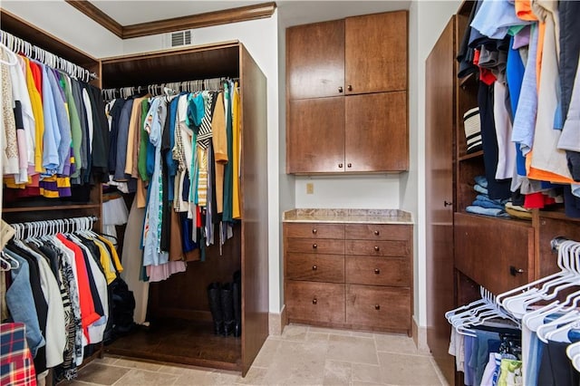 walk in closet with stone finish floor and visible vents