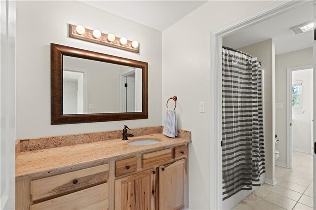 bathroom featuring visible vents, toilet, a shower with shower curtain, tile patterned floors, and vanity