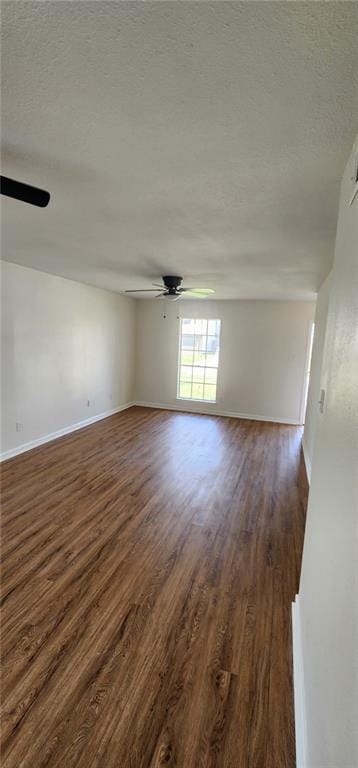 unfurnished room featuring dark wood finished floors, baseboards, a textured ceiling, and ceiling fan