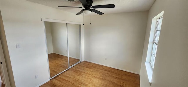 unfurnished bedroom featuring a closet, ceiling fan, baseboards, and wood finished floors