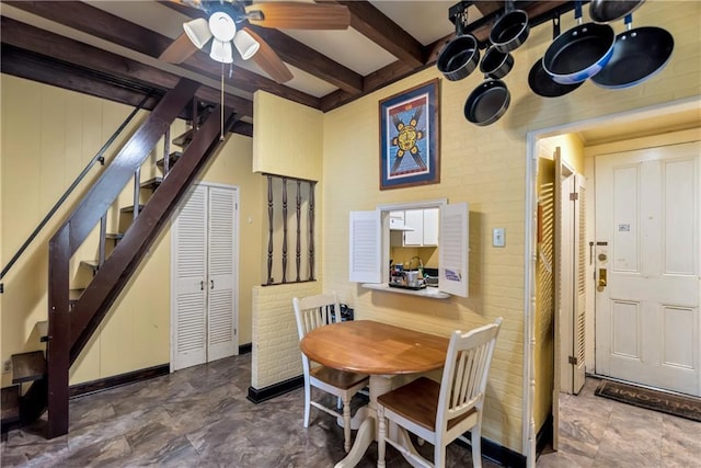 dining space with beamed ceiling, a ceiling fan, and stairs