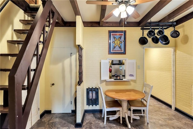 dining area with beamed ceiling, ceiling fan, and stairs