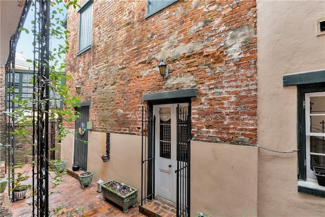 view of exterior entry with a patio area