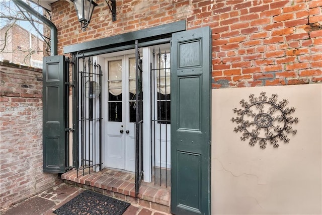 doorway to property featuring brick siding