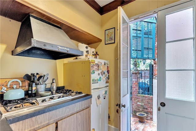 kitchen featuring wall chimney range hood and stainless steel gas stovetop