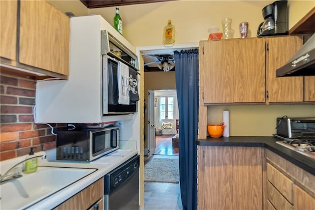 kitchen featuring a sink, appliances with stainless steel finishes, wall chimney exhaust hood, and a toaster