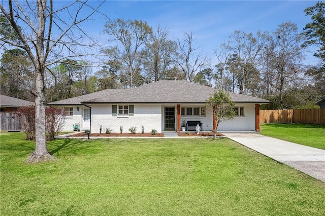 single story home featuring brick siding, concrete driveway, a front lawn, and fence