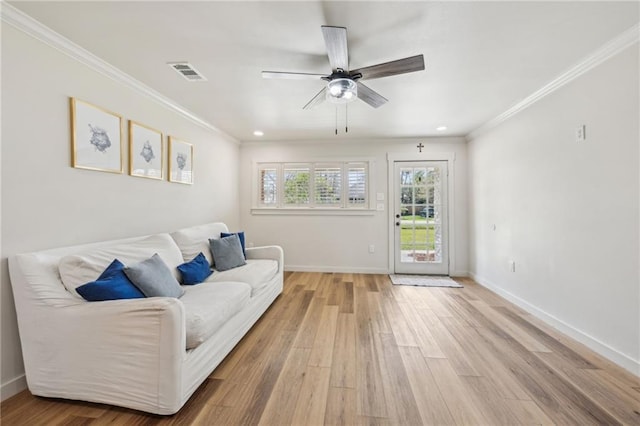 living area featuring crown molding, visible vents, and light wood-type flooring