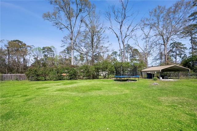 view of yard with a detached carport and a trampoline