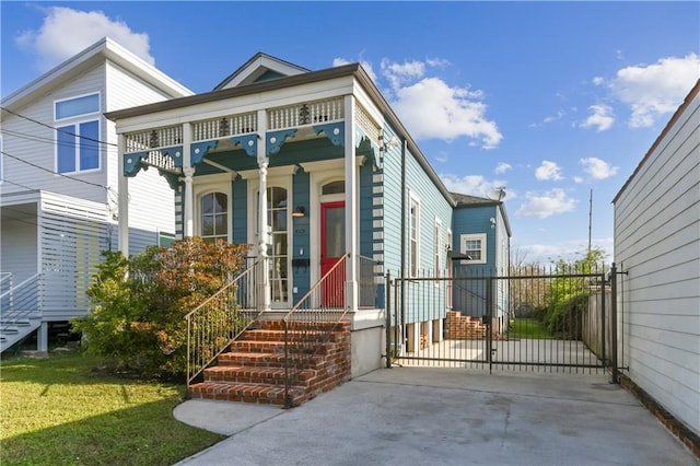 view of front facade featuring a gate, a front yard, and fence