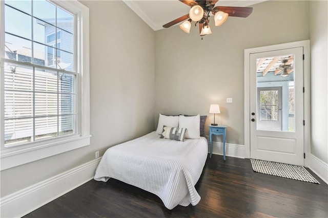 bedroom featuring dark wood-style floors, a ceiling fan, crown molding, and baseboards