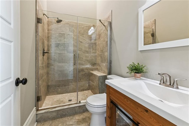 full bath with a stall shower, toilet, and vanity