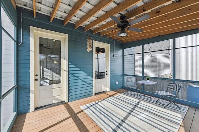 unfurnished sunroom featuring ceiling fan