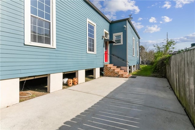 view of home's exterior featuring entry steps and fence