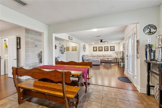 dining space featuring light tile patterned flooring, visible vents, a textured ceiling, and a ceiling fan