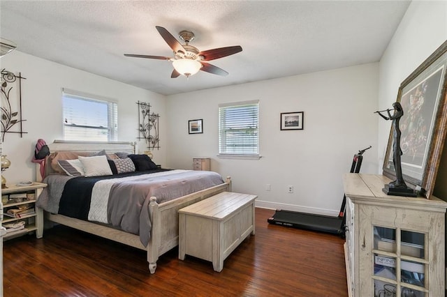 bedroom featuring multiple windows, baseboards, dark wood-style flooring, and a textured ceiling