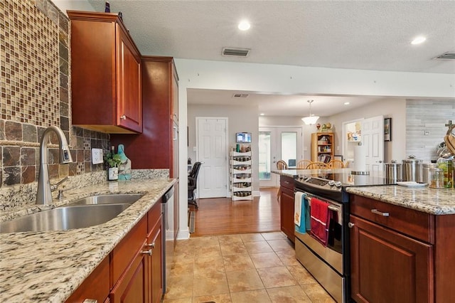 kitchen featuring visible vents, a sink, backsplash, stainless steel appliances, and light tile patterned floors