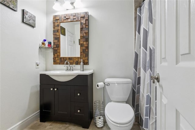 bathroom with vanity, toilet, and baseboards