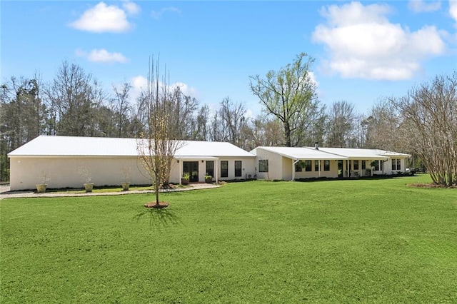 rear view of property with a lawn