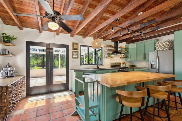 kitchen featuring open shelves, stainless steel appliances, wood counters, and green cabinetry