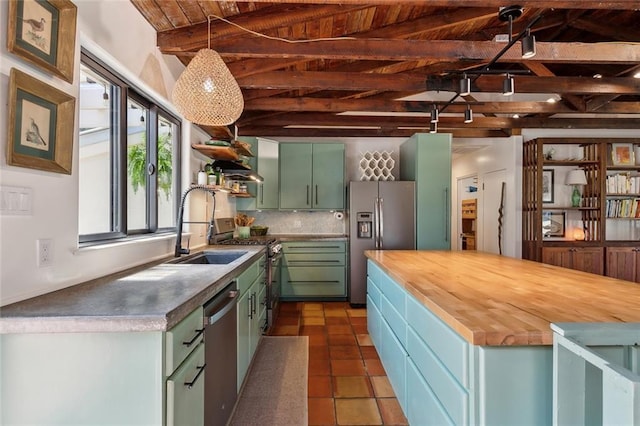 kitchen with open shelves, a sink, appliances with stainless steel finishes, wood counters, and green cabinets