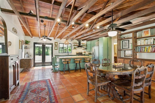 tiled dining space featuring wood ceiling, beam ceiling, french doors, a ceiling fan, and a sink
