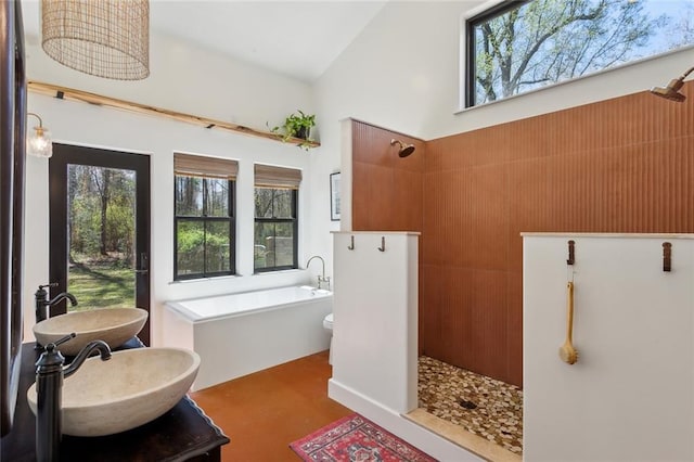 bathroom with a bathing tub, a walk in shower, and a sink