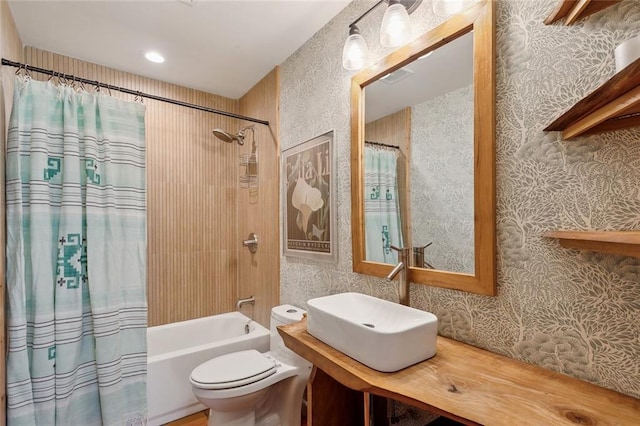 bathroom featuring visible vents, wallpapered walls, a sink, shower / bath combination with curtain, and toilet
