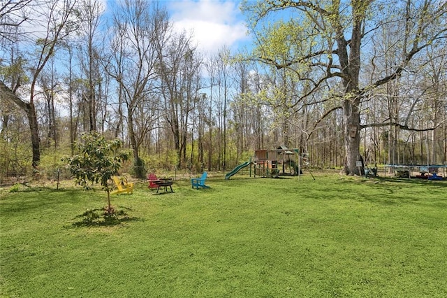 view of yard with a trampoline and a playground