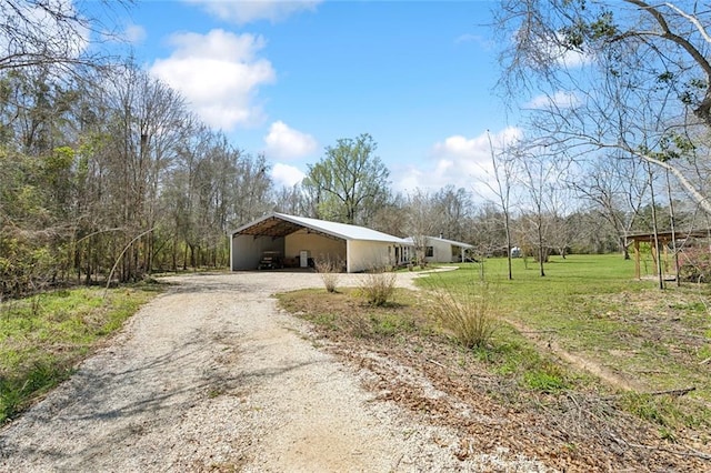 view of property exterior with a yard and dirt driveway