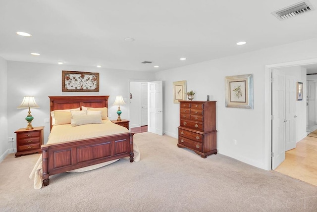 bedroom with light colored carpet, recessed lighting, visible vents, and baseboards