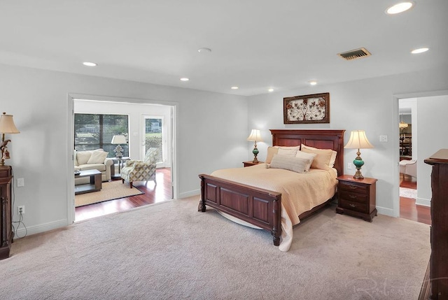 bedroom with visible vents, recessed lighting, light colored carpet, and baseboards