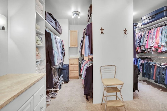 walk in closet featuring light colored carpet