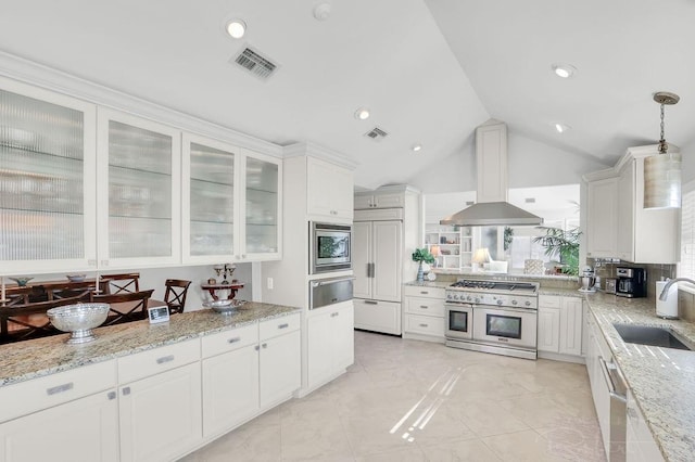 kitchen with island exhaust hood, a sink, white cabinets, built in appliances, and a warming drawer