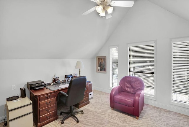 office area featuring baseboards, light carpet, ceiling fan, and vaulted ceiling